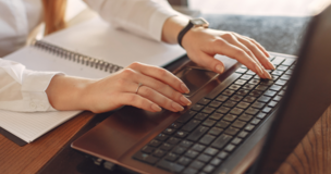 kobiece dłonie na klawiaturze laptopa