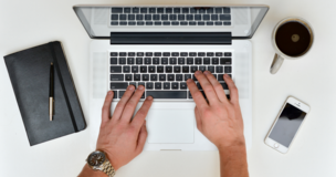 męskie dlonie piszące na klawiaturze laptopa