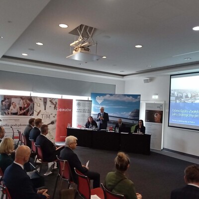 uczestnicy konferencji z wyświetloną prezentacja multimedialną