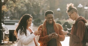 grupa studentów spacerujących i patrzących w telefony