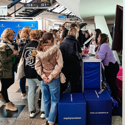 grupa studentów zgromadzonych wokół stoiska promocyjnego