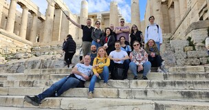 Group sitting on ancient stone steps outdoors during the first consortium meeting of the SILWERS project.