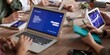 grupa ekspertów zgromadzona przy stole konferencyjnym z laptopami, tabletami i smartfonami