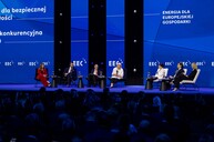 Panel inaugurujący Europejski Kongres Gospodarczy 2025. Na scenie siedzi siedmioro prelegentów biorących udział w dyskusji „Energia dla europejskiej gospodarki”. Wśród nich obecna jest Minister Przemysłu dr hab. Marzena Czarnecka, prof. UE. Wydarzenie odbywa się w nowoczesnej oprawie multimedialnej, a tło sceny tworzy intensywnie niebieska grafika z logotypami EEC i hasłem przewodnim kongresu. Publiczność licznie zgromadzona na widowni uważnie śledzi debatę.
