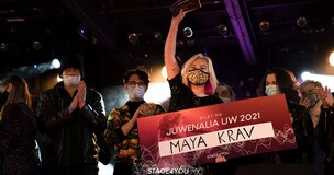 dziewczyna, zwyciężczyni konkursu, trzyma w rękach dyplom, pozostali uczestnicy klaszczą