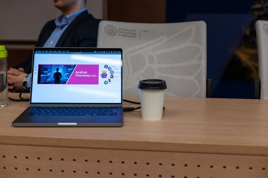 laptop na biurku, obok kubek
