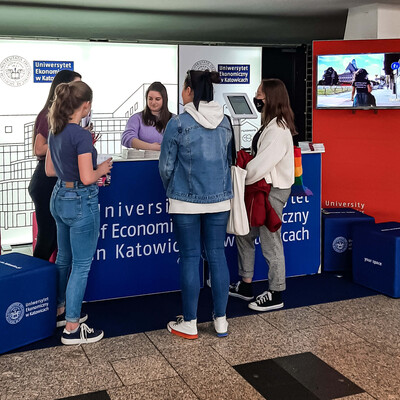 grupa studentów zgromadzonych wokół stoiska promocyjnego