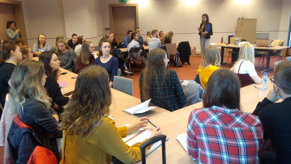 Uczestnicy projektu Akademia Kariery, siedzą przy stolikach i słuchają prelegenta