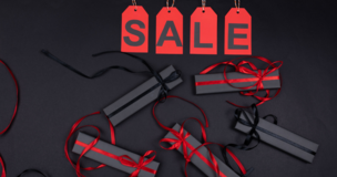 napis sale oraz prezenty leżą na czarnym tle