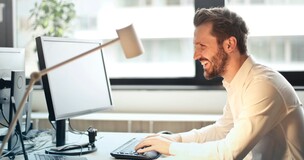 mężczyzna siedzący przez komputerem