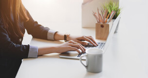 obrazek przedstawia osobę pracująca przed laptopem.