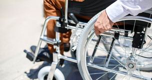 Obrazek przedstawia mężczyznę siedzącego na wózku inwalidzkim.