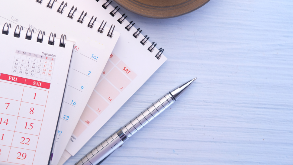 notes, calender and pen lie down on the desk